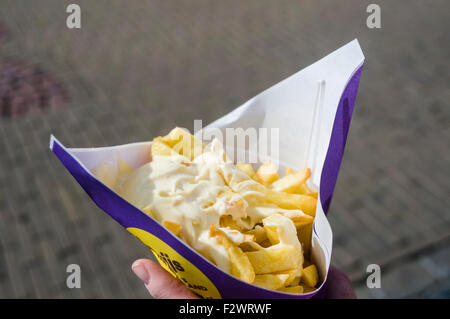 Frau hält einen Kegel Chips Pommes Frites mit Mayonnaise in Holland Stockfoto