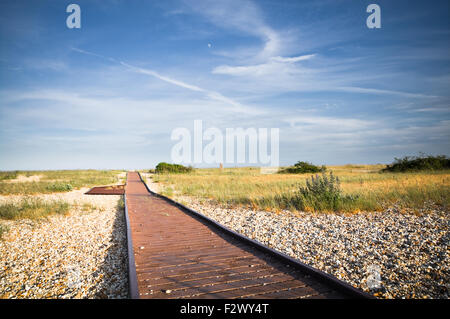 Eine Promenade Pfad über den Steinen an Pagham Harbour, West Sussex, England. Stockfoto