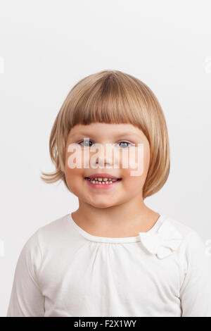 Lächelnd süß kaukasischen kleines Mädchen, Closeup Studioportrait auf hellgrauen Hintergrund Stockfoto