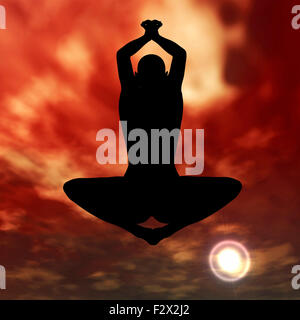 Silhouette praktizieren Yoga am Himmel bei Sonnenuntergang Stockfoto