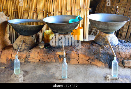 Eine ländliche Distillery machen Reiswein. Destillation erfolgt in Feuer beheizten irdenen Stills und Alkohol sammelt in Flaschen. Norden Myanmar (Birma) Stockfoto