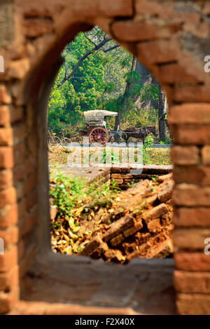 Schauen Sie durch Wandöffnung von Pferd und Wagen wartet auf Touristen im ländlichen Tempel in der Nähe von Inwa (Ava), Myanmar (Burma, Birma) Asien Stockfoto