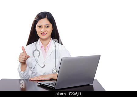 1 indische Arzt Mann sitzen Tisch arbeiten Laptop und Daumen nach oben zeigen Stockfoto