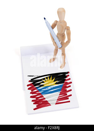 Hölzerne Puppe gemacht eine Zeichnung einer Flagge - Antigua und Barbuda Stockfoto