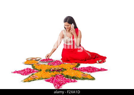 1 Erwachsenen Frau Diwali Indianerfest Rangoli entwerfen und Handy im Gespräch Stockfoto