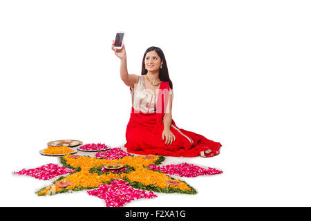 1 indische erwachsenen Frau Diwali Festival entwerfen Rangoli und Handy selfie Stockfoto