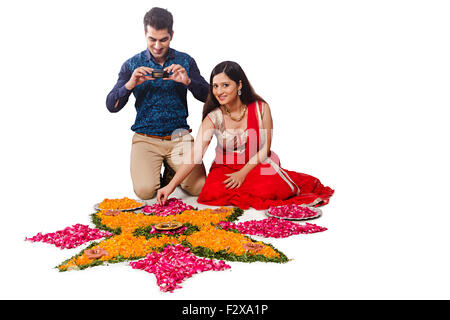 2 indische verheiratet paar Diwali Festival entwerfen Rangoli und Kamera klicken auf Bild Stockfoto