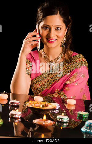 1 indische erwachsenen Frau Diwali Festival Dekoration Diya und sprechende Handy Stockfoto