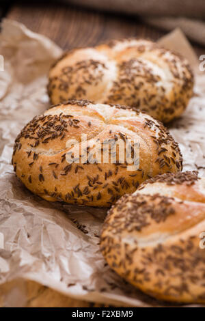 Frisch gebackene Brötchen (mit Kümmel) auf rustikalen hölzernen Hintergrund Stockfoto