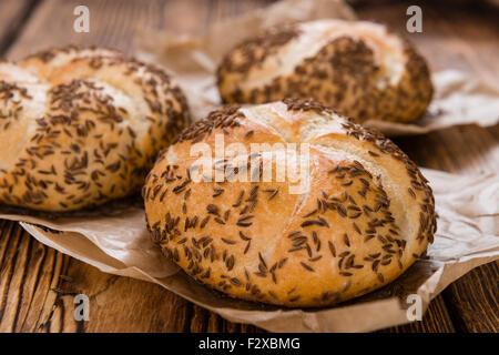 Frisch gebackene Brötchen (mit Kümmel) auf rustikalen hölzernen Hintergrund Stockfoto