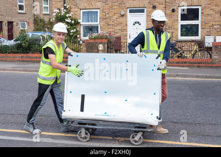 Bauarbeiter transportieren Glasscheibe, Grüner Drache Lane, Brentford, Greater London, England, Vereinigtes Königreich Stockfoto
