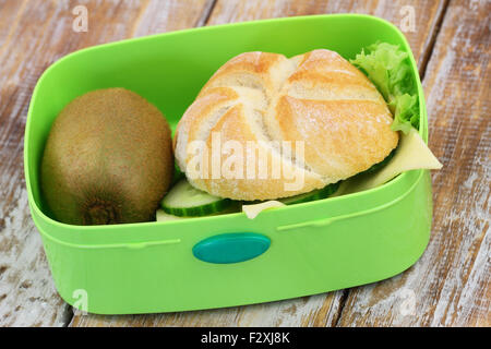 Lunch-Box mit gesunden Inhalt: Käse-Brot-Roll und Kiwi-Frucht Stockfoto