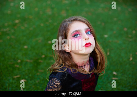 Halloween Make-up Kind Mädchen mit blauen Augen in Outdoor-Garten-Rasen Stockfoto