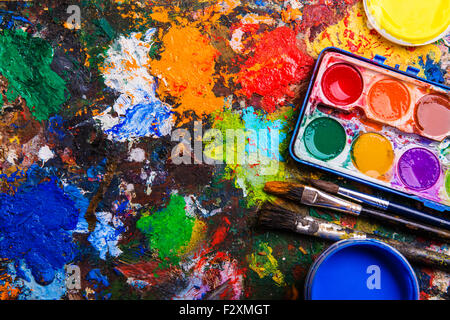 Schreibtisch des Künstlers mit Aquarellfarben und Pinsel. Stockfoto