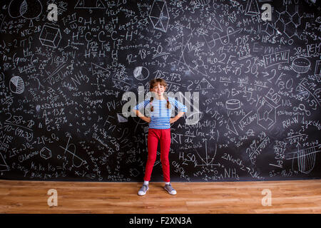 Niedliche kleine Mädchen vor große Tafel Stockfoto