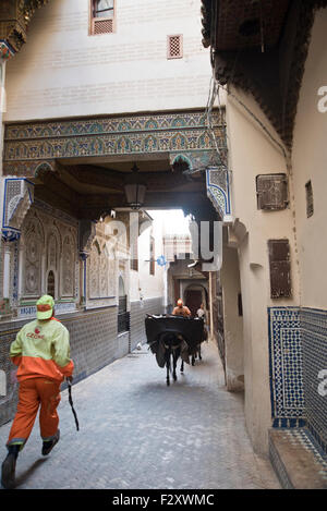 Schmale Straße in der Medina von Fez; die Mauer des Mausoleums Moulay Idriss mit Mosaikdetails auf der rechten Seite. Stockfoto