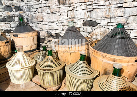 Korbflaschen Wein in ein Steinkeller. Stockfoto