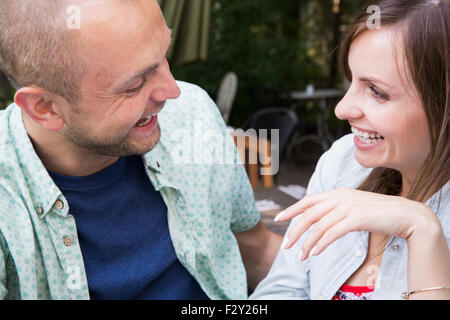 Ein junger Mann und Frau, ein paar sitzen draußen in einem Café zusammen. Stockfoto