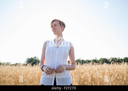 Halblängen Porträt einer jungen Frau, stehend in einem Maisfeld. Stockfoto