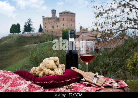 Stillleben von weißen Trüffel aus Piemont, Trüffel Schnitten und Flasche mit Glas Rotwein, mit Blick auf die Weinberge und th Stockfoto