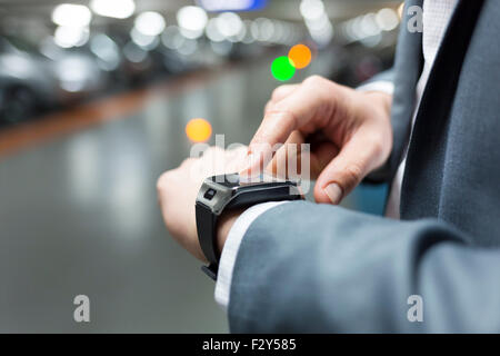Verwenden in Parken einen Mann seine Smartwatch. Close-up Hände Stockfoto