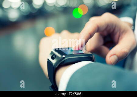 Verwenden in Parken einen Mann seine smart-Uhr. Close-up Hände Stockfoto