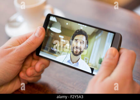 Nahaufnahme einer männlichen Hand hält ein intelligentes Telefon während einer Skype video Stockfoto