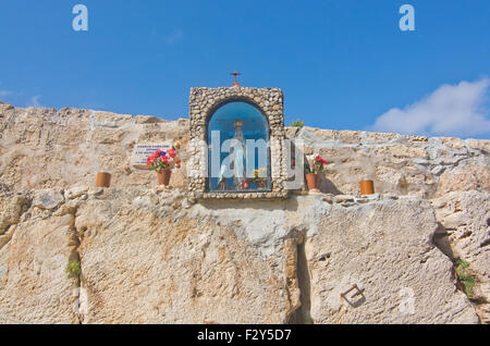 Religiösen Schrein mit Inschrift, schützende Madonna und Blumen an einem sonnigen Tag im blauen Grotte, Malta. Stockfoto