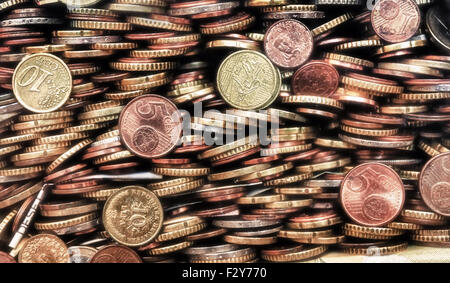 Münzen der verschiedenen Länder aufgetürmt einer auf die andere Form eine homogene Zusammensetzung. Metalle in verschiedenen Farben. Stockfoto