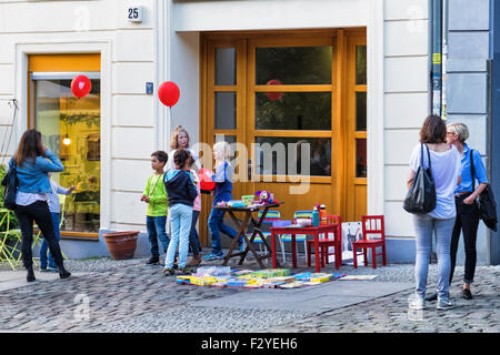 Berlin Veteranenstrasse Street Party - Street-Veteran Fest - junge Kinder verkaufen unerwünschte Spielzeug am Stall auf Bürgersteig Stockfoto