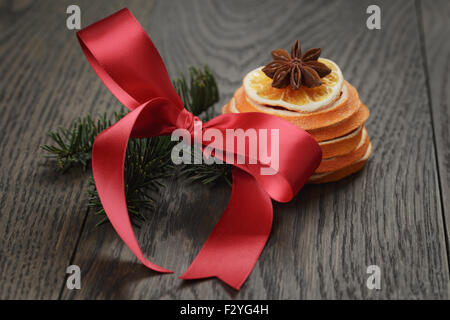 Fichte Zweig mit roter Schleife und Orangenscheibe, Weihnachten Stockfoto