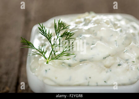 Schüssel mit frischem Knoblauch-Käse-Sauce auf alten rustikalen hölzernen Hintergrund Stockfoto