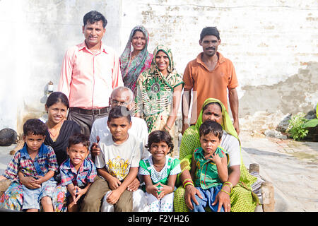 indische Gruppe Massen ländlichen Dorfbewohner gemeinsame Familie Zuhause sitzen Charpai Stockfoto