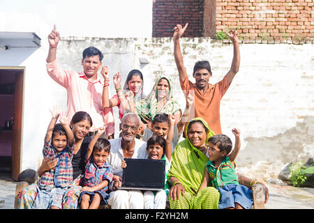 indische Gruppe Massen ländlichen Dorfbewohner gemeinsame Familie Hause Laptop zeigt Stockfoto