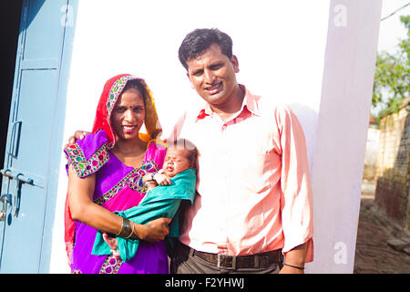 3 indischen ländlichen Bauern Eltern und Baby Care stehende Haus Stockfoto