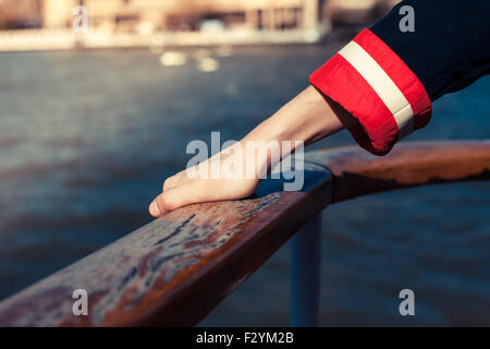 Closeup auf die Hand einer Frau hält das Geländer auf dem Deck eines Schiffes Stockfoto