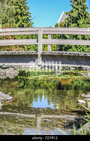 Fotografiert an einem Sommertag der Holzbrücke über den Koiteich in Kasugai Gärten, Kelowna Stockfoto