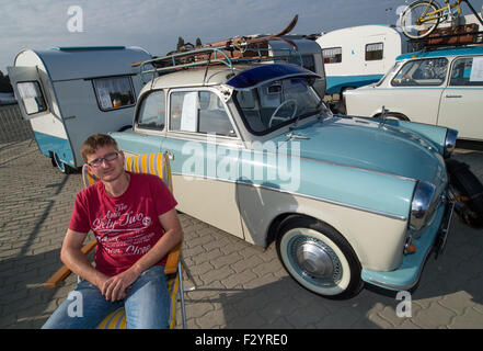 Lauchhammer, Deutschland. 26. Sep 2015. Ingo Mueckel stellt neben seinem Trabant 500 Auto Baujahr 1960, als er in der 3. Elbflorenz-Rallye auf dem Gelände der Firma Vestas in Lauchhammer, Deutschland, 26. September 2015 teilnimmt. Rund 150 Personen nahmen an der diesjährigen Oldtimer-Rallye aus Dresden in den südlichen Teil des Bundeslandes Brandenburg und zurück. Foto: PATRICK PLEUL/Dpa/Alamy Live News Stockfoto