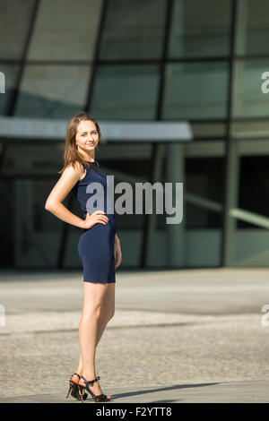 Junge schlanke Geschäftsfrau, Business-Center im Hintergrund. Stockfoto