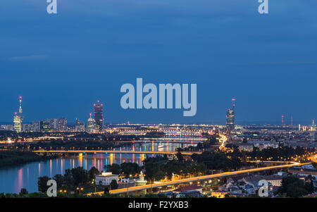 Ein Blick auf Gebäude und Brücken in der Nähe der Donau in Wien in der Nacht. Es gibt Platz für Text. Stockfoto