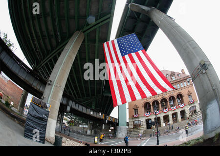 RICHMOND, VIRGINIA, 26. Sept. 2015. Während der 130 Kilometer langen 2015 Junioren UCI Road World Championship Rennen der Junioren Feld reitet Vergangenheit eine amerikanische Flagge auf der Main Street Station Bereich von Richmond, Virginia. Credit: Ironstring/Alamy leben Nachrichten Stockfoto