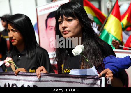 La Paz, Bolivien, 26. September 2015. Evaliz Morales Alvarado (links, Tochter des bolivianischen Präsidenten Evo Morales) führt einen marsch zur mexikanischen Botschaft in La Paz, um dem ersten Jahrestag des Verschwindens von 43 Studenten in Mexiko zu gedenken. Die Studenten verschwanden in der Nacht des 26. September 2014 in der Stadt Iguala im Bundesstaat Guerrero. Die Behandlung des Falls durch die mexikanische Regierung wurde weithin kritisiert, und ein Team der Interamerikanischen Menschenrechtskommission fand eine Reihe von Fehlern in der Untersuchung der Regierung. Stockfoto