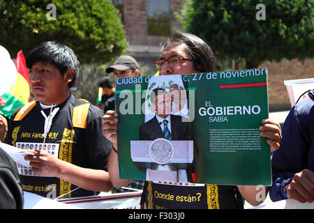 La Paz, Bolivien, 26. September 2015. Demonstranten vor der mexikanischen Botschaft in La Paz Gedenken den ersten Jahrestag des Verschwindens von 43 Studenten in Mexiko. Die Schüler verschwand in der Nacht des 26. September 2014 in die Stadt Iguala im Bundesstaat Guerrero. Ein Team der Interamerikanischen Kommission für Menschenrechte per fand eine Reihe von Mängeln in der Regierung Untersuchung. Die mexikanische Regierung Bearbeitung des Falls ist weit kritisiert worden, ein Demonstrant hält eine Kopie von einem Zeitschriftenartikel, beschuldigte die Regierung, mitschuldig an das verschwinden. Stockfoto