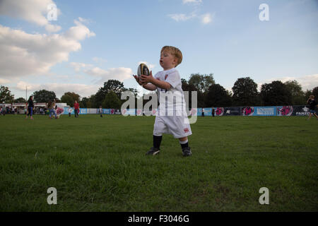 Richmond, London, UK. 26. Sep 2015. Ein Kleinkind übt seine Fähigkeiten mit dem ovalen Ball bei einem Outdoor-Rugby World Cup-Vorführung am Londoner Old Deer Park, Richmond, SW. Hunderte von Fans versammelt, um eine Reihe von Matches auf großen Leinwänden nicht weit von Twickenham Stadium zu sehen. Bildnachweis: Auf fotografischen Blick/Alamy Live News Stockfoto