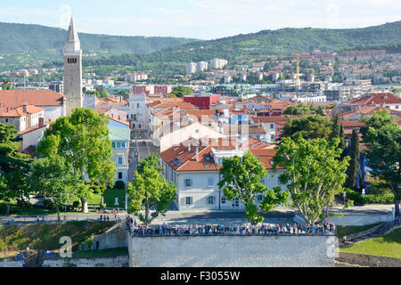 Koper Slowenien Städte Menschen auf der Adria Küste beobachten die Abreise von einem Kreuzfahrtschiff mit Blick auf die Skyline der Stadt jenseits der Halbinsel Istrien. Stockfoto