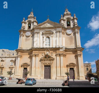 Barocke Kirchenbau mit eisernen Kanonen innerhalb der alten Stadtmauern an einem sonnigen Tag im September in Mdina, Malta. Stockfoto