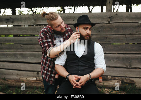 Barbier rasiert ein bärtigen Mannes Stockfoto