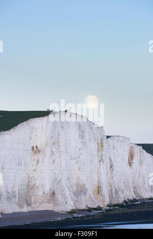 Ein Supermoon steigt über die sieben Schwestern in Sussex, Teil des South Downs National Park im Vereinigten Königreich Stockfoto