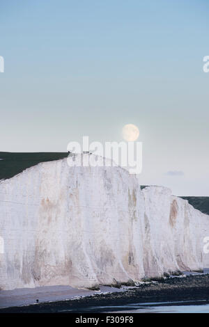 Ein Supermoon steigt über die sieben Schwestern in Sussex, Teil des South Downs National Park im Vereinigten Königreich Stockfoto