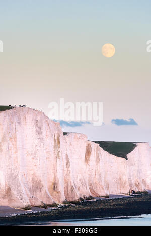 Ein Supermoon steigt über die sieben Schwestern in Sussex, Teil des South Downs National Park im Vereinigten Königreich Stockfoto